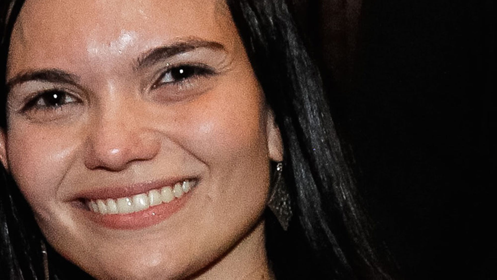 A woman with long black hair smiling for the camera.
