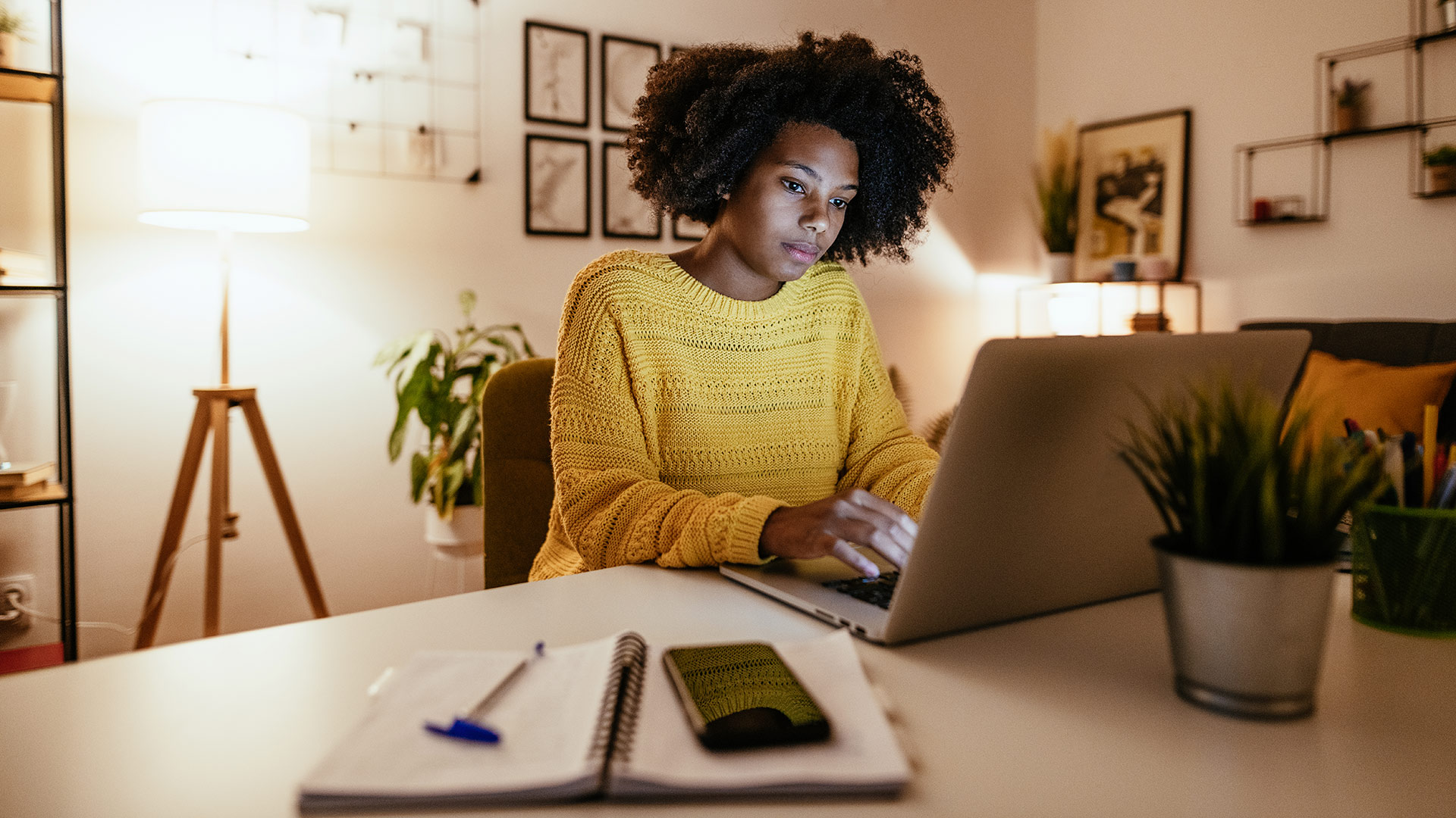 A woman working on her laptop at home at night.